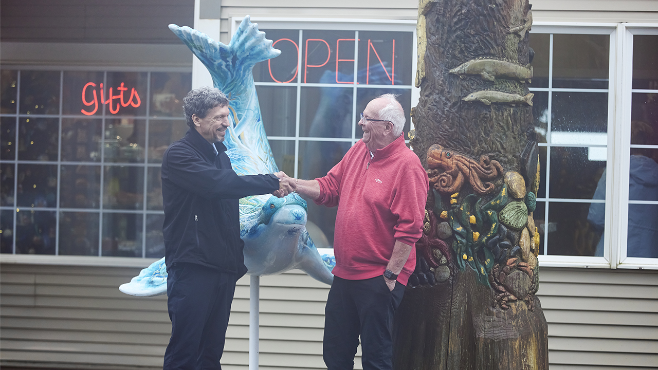 OPB banker greets owner of Sea Lion Caves out front of business.