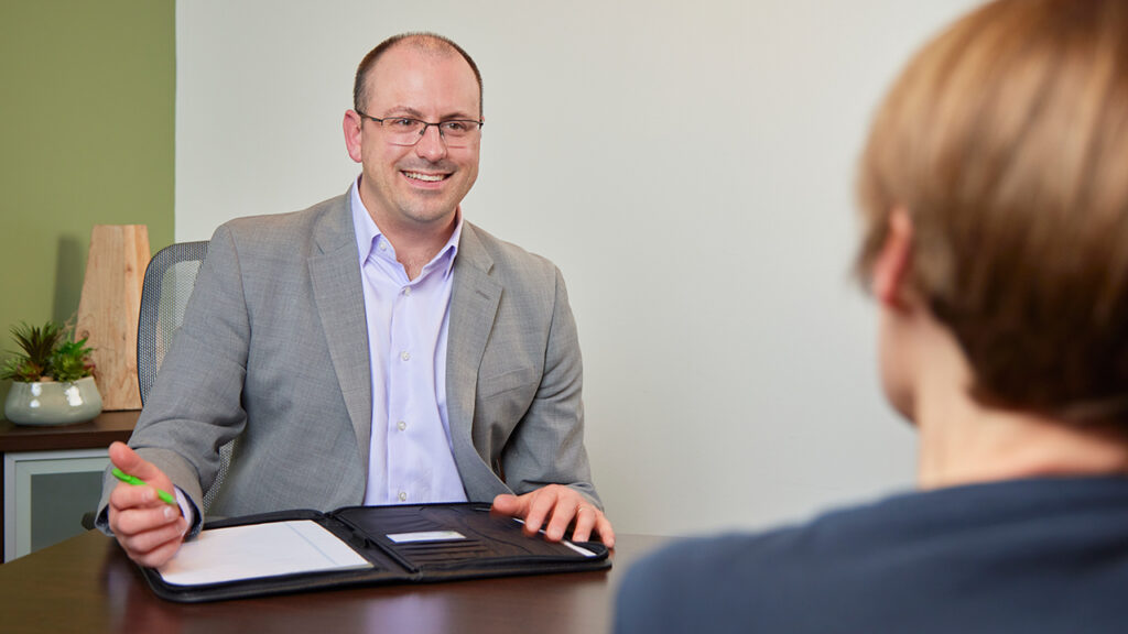 Banker sitting in his office, smiling.