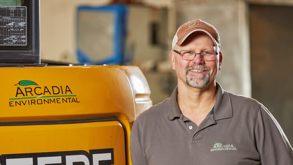 Business owner stands next to equipment.