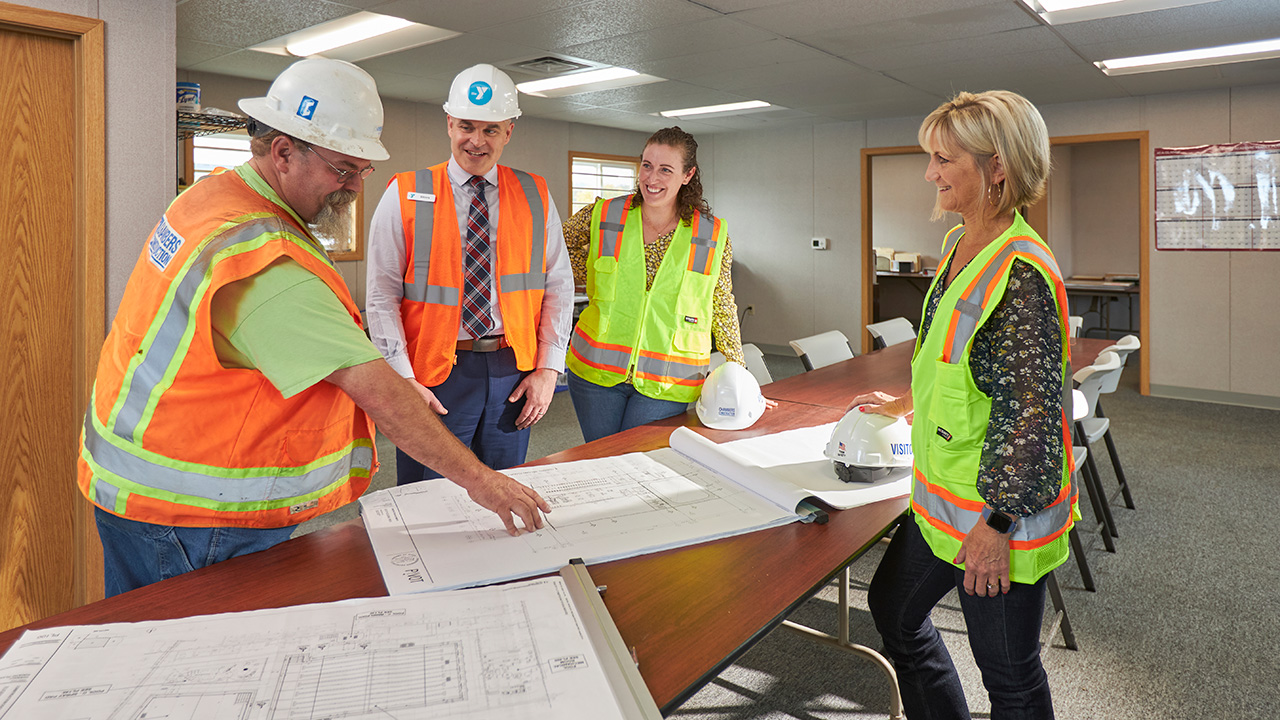 Gathered around a table looking at construction plans.