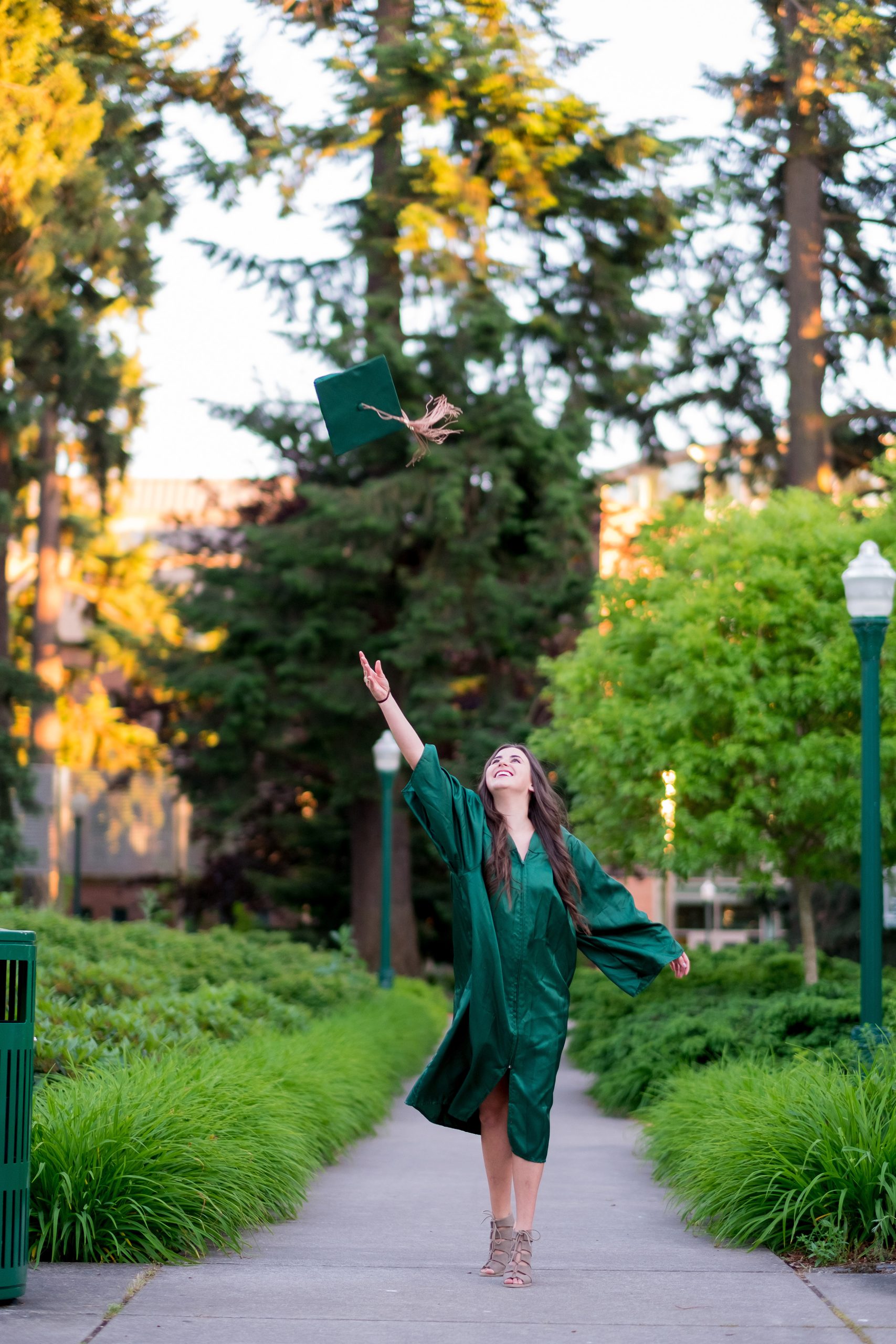 College grad student throwing hat in the air before graduation ceremonies.